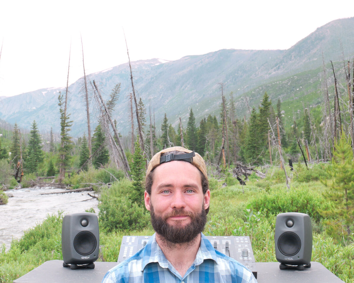 Josh mixing on portable monitors beside a mountain creek